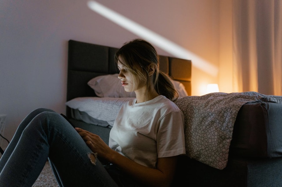 A young woman, victim of domestic violence, searching online for legal protection and support.