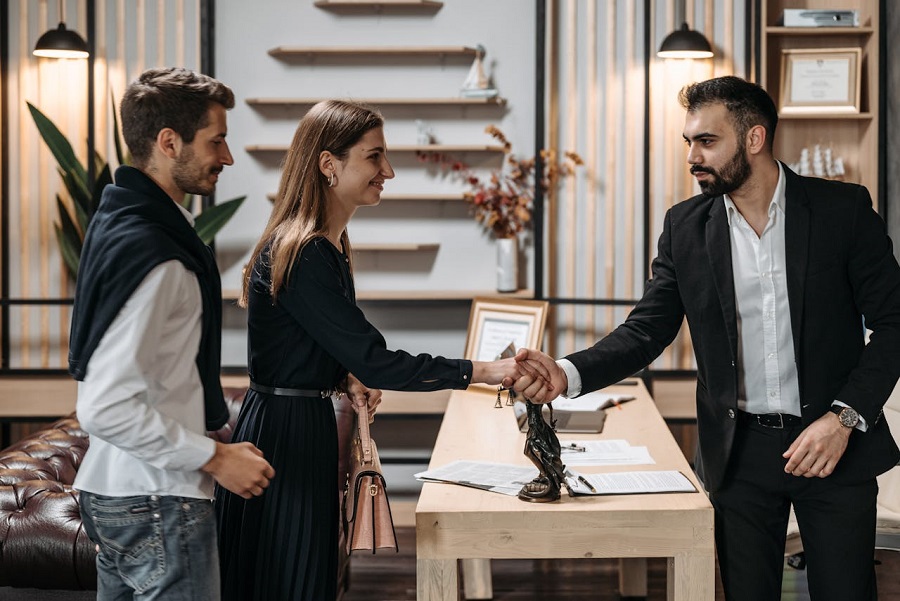 A man and a woman shaking hands with a lawyer