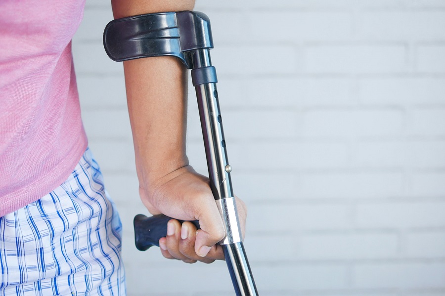a person holding a crutch and a walking cane