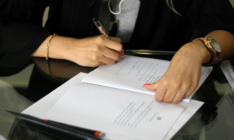 a person writing on a piece of paper 