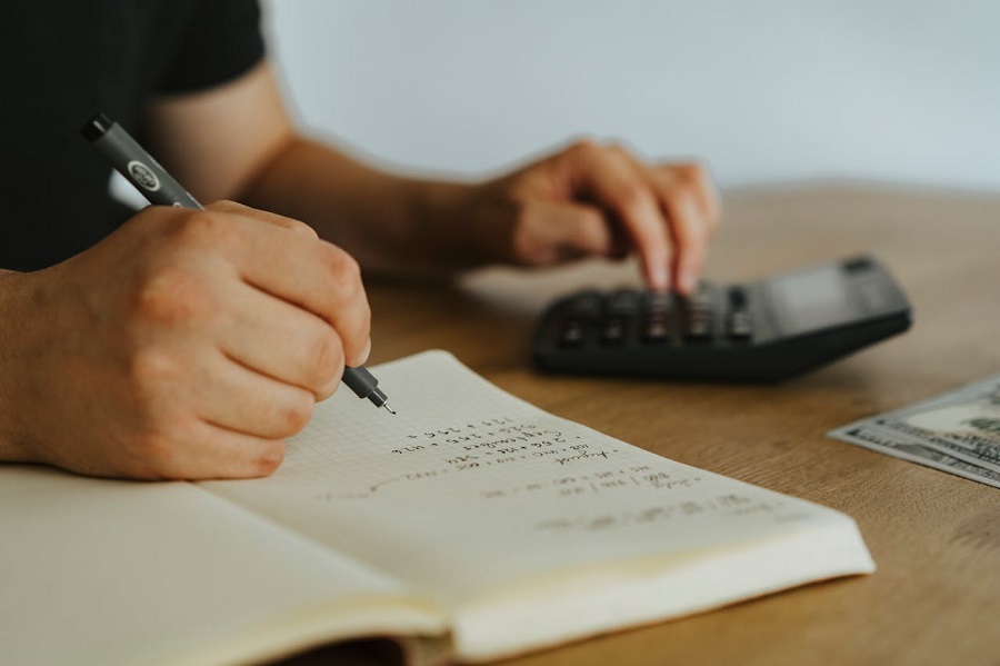 a person writing on white paper 