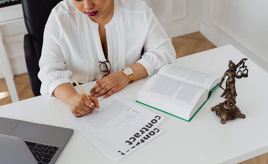 a lawyer in White Long Sleeves Writing on White Paper