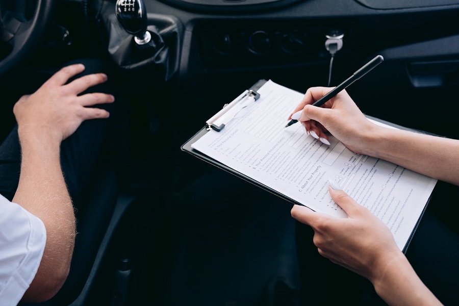 Person Writing on a Clipboard Inside the Vehicle 