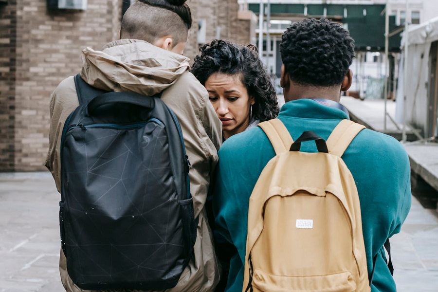 young men bullying young woman on street