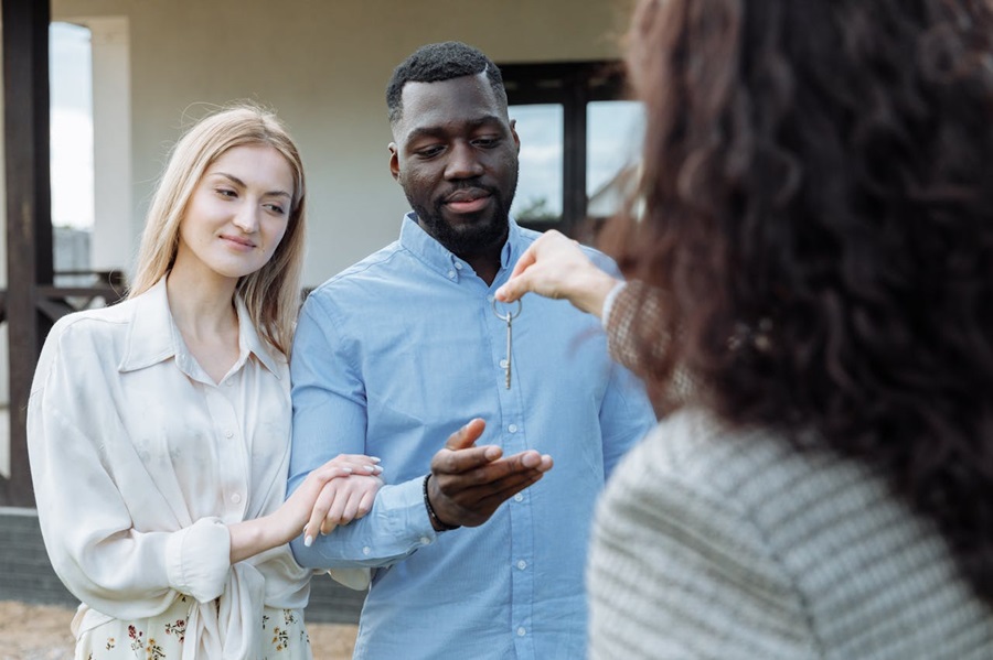 A couple receives keys from a real estate agent, marking a successful property transfer.