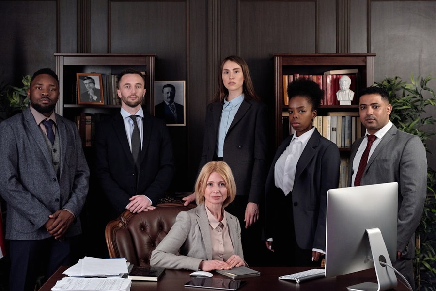Group of six legal professionals posing in an office setting.