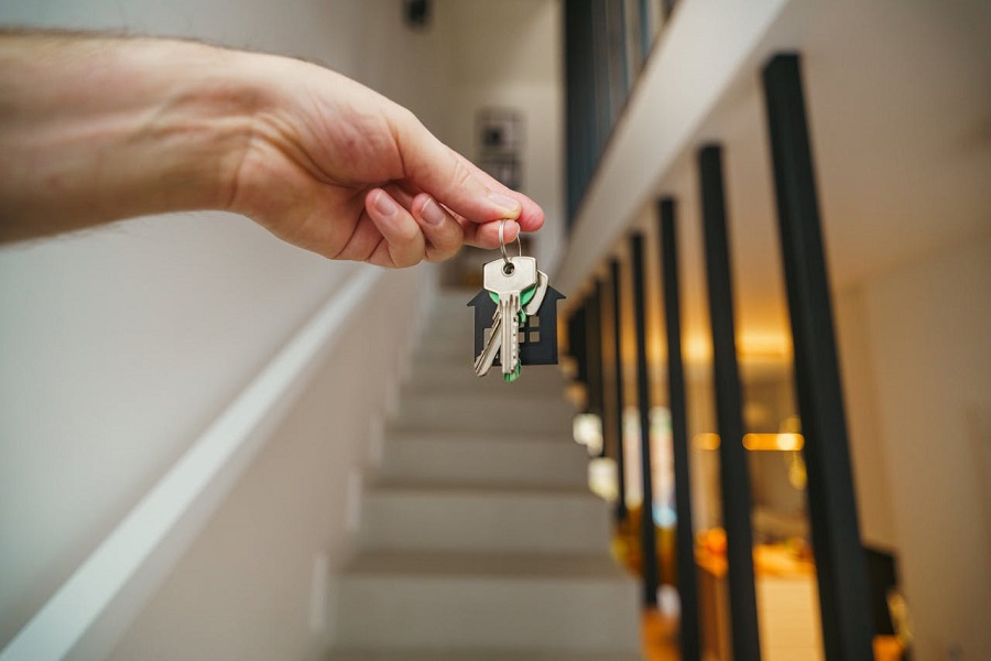 Tenant hand holding house keys in a modern interior