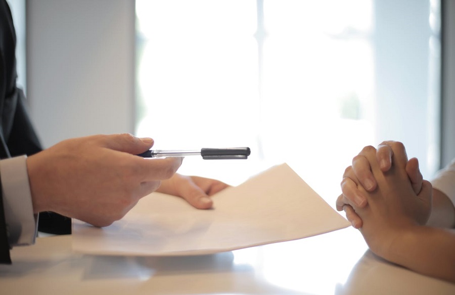Crop businessman giving contract to woman to sign