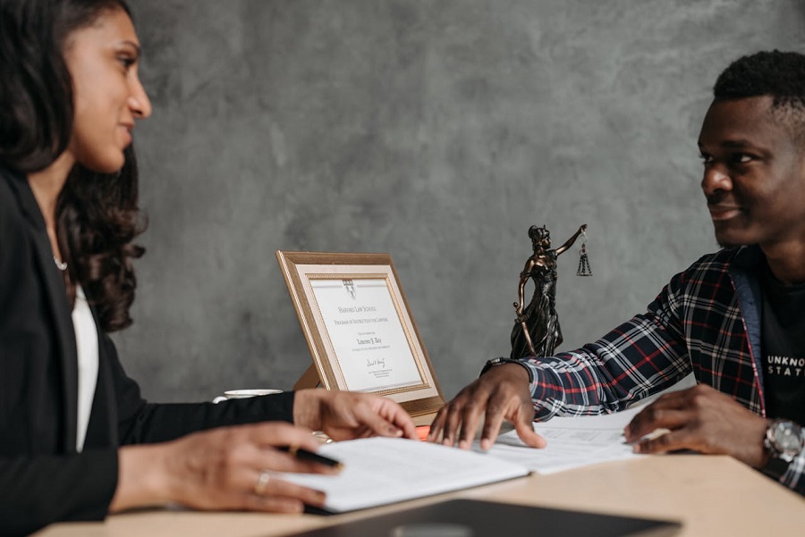 A Man and a Woman Sitting at the Office Table with White Paper in Front