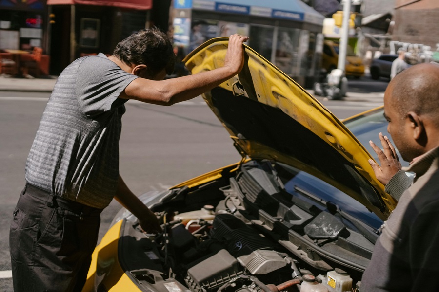 Customer and staff inspecting a rental car for damage
