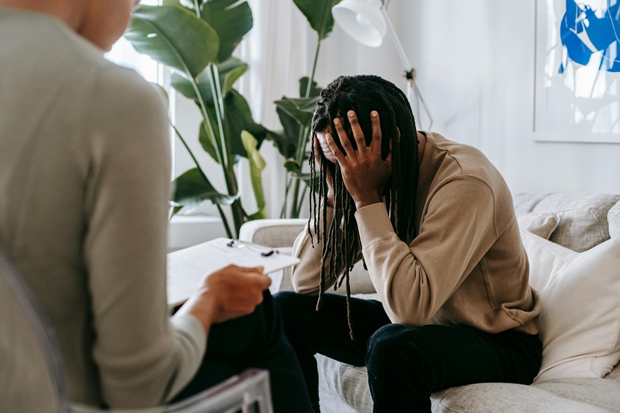 Person in distress speaking with a therapist about mental health issues