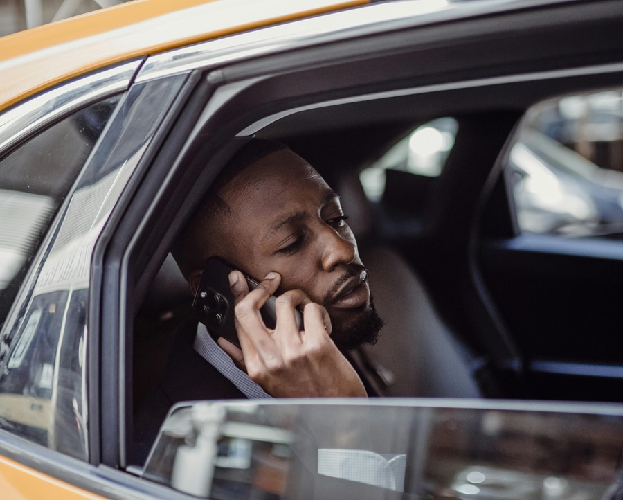 Taxi passenger reporting accident on phone from car back seat