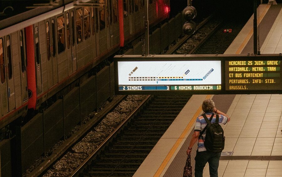 Passenger checking train information board at station platform during service disruption