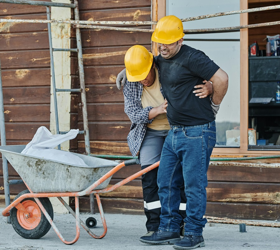 Injured worker helped by colleague on construction site