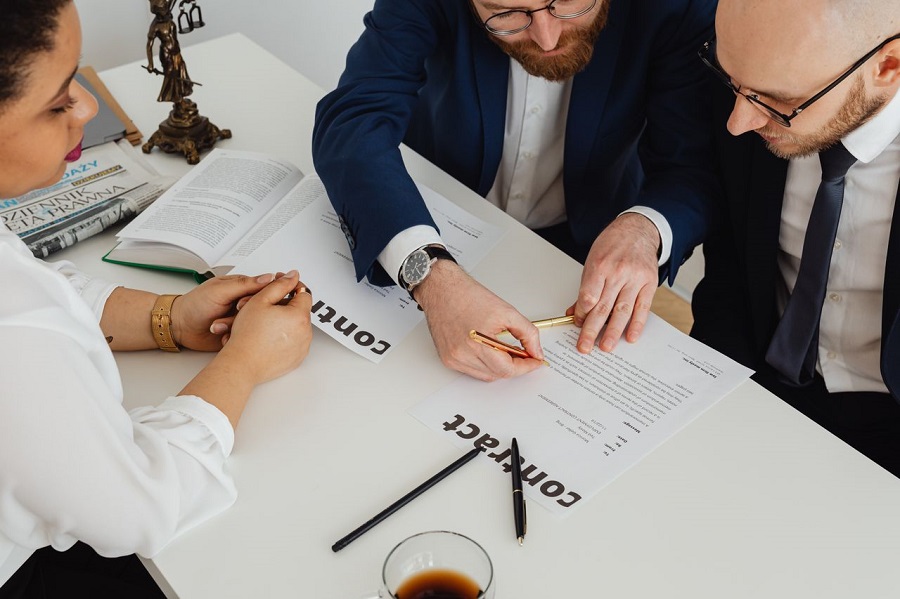 Two clients and a lawyer signing a UK commercial contract including a force majeure clause