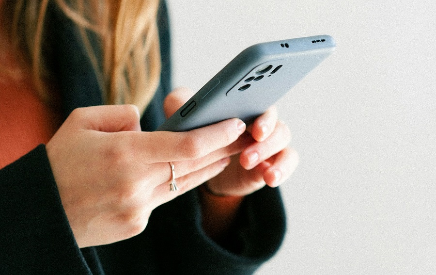 a woman holding a phone in her hands, reading a blackmail