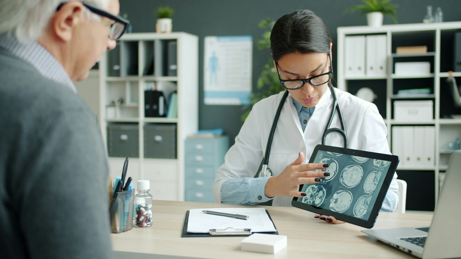  A doctor shows brain scans to a patient on a tablet to prove medical negligence